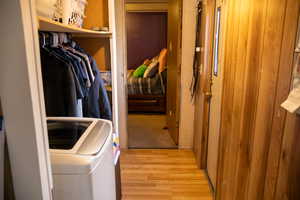 Clothes washing area featuring separate washer and dryer and light hardwood / wood-style floors