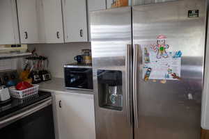 Kitchen featuring stainless steel appliances and white cabinetry