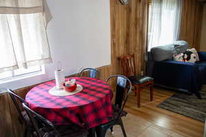 Dining area featuring light wood-type flooring and wood walls