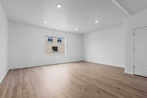 Spare room featuring beam ceiling and light wood-type flooring