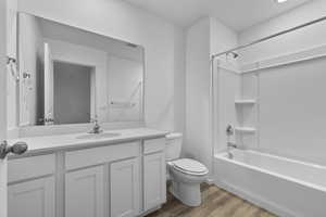 Full bathroom featuring toilet, hardwood / wood-style flooring, vanity, and shower / bathing tub combination