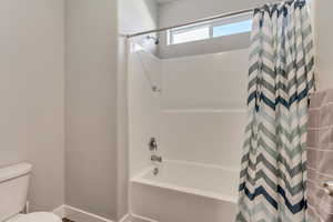 Bathroom featuring toilet and shower / bath combo