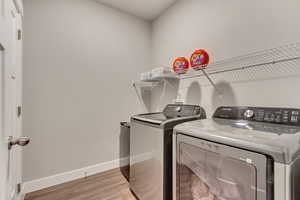 Laundry room featuring hardwood / wood-style floors and washing machine and clothes dryer