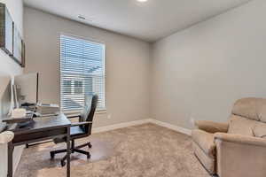 Office space featuring light carpet and plenty of natural light