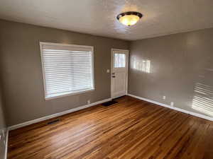 Foyer with hardwood / wood-style floors and a textured ceiling