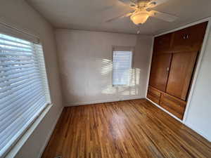 Unfurnished bedroom featuring ceiling fan, wood-type flooring, and a closet