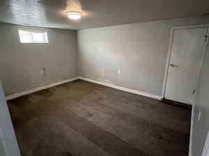 Carpeted spare room featuring a textured ceiling