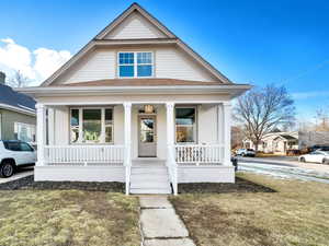 Bungalow with a front yard and a porch