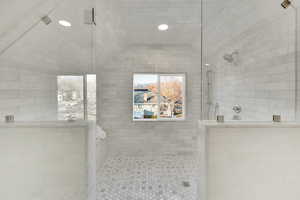 Bathroom featuring vaulted ceiling and tiled shower