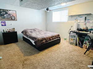 Bedroom with a textured ceiling and carpet floors