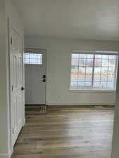 Entryway with light wood-type flooring and a textured ceiling