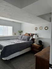 Bedroom featuring a textured ceiling and carpet