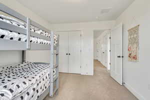 Carpeted bedroom with a closet