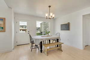 Dining area featuring an inviting chandelier and light wood-type flooring