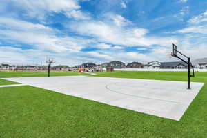 View of basketball court with a yard