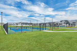 View of tennis court featuring a yard