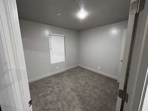 Empty room with carpet floors and a textured ceiling