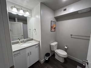 Bathroom with hardwood / wood-style floors, toilet, and vanity