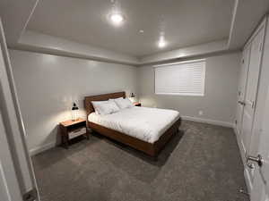 Carpeted bedroom with a tray ceiling and a textured ceiling