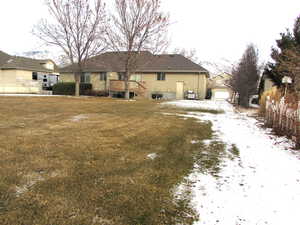 View of backyard looking East featuring lawn with full sprinkler system