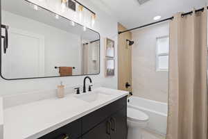 Full bathroom with toilet, vanity, and shower / bath combination with curtain