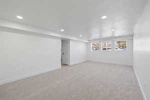 Carpeted spare room with a textured ceiling