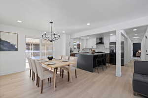 Dining space with a notable chandelier, sink, and light hardwood / wood-style floors