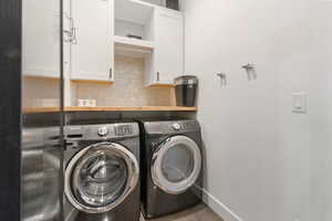 Washroom with cabinets and independent washer and dryer