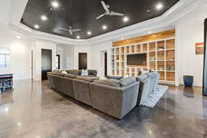 Living room with ceiling fan and a tray ceiling