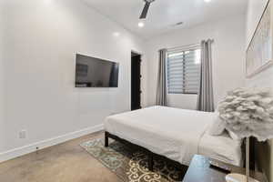 Bedroom featuring ceiling fan and concrete floors