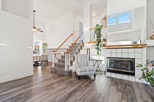 Entrance to open living space featuring a tiled fireplace, vaulted ceilings, and LVP flooring