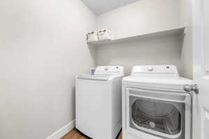 Laundry room featuring light wood-type flooring and washing machine and clothes dryer