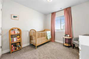 Bedroom featuring carpet floors and a crib