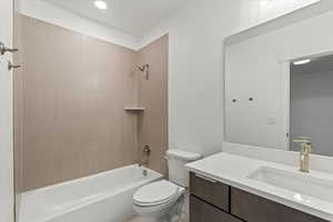 Full bathroom featuring toilet, vanity, and tiled shower / bath