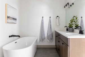 Bathroom featuring a bathing tub and vanity