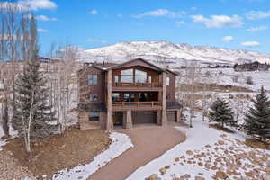 View of front of home with a garage, a balcony, and a mountain view