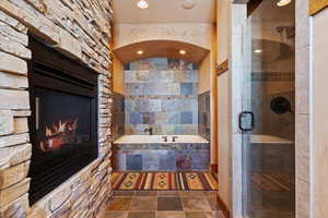 Bathroom with plus walk in shower and a fireplace