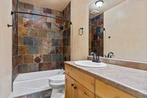 Full bathroom featuring toilet, vanity, and shower / tub combination