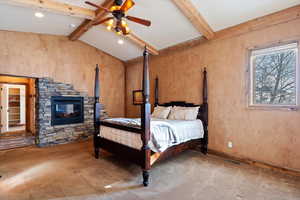 Carpeted bedroom with ceiling fan and lofted ceiling with beams