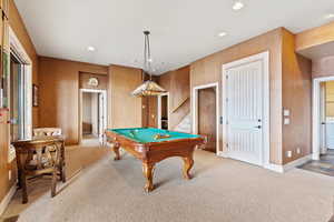 Rec room with carpet, billiards, washer / dryer, and wooden walls