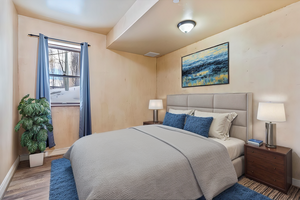 Bedroom featuring light wood-type flooring and a baseboard heating unit