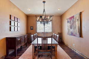 Dining room with a chandelier and dark hardwood / wood-style floors