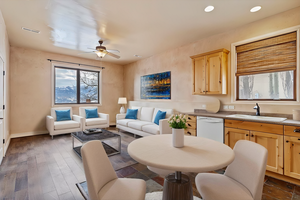 Interior space featuring dishwasher, light brown cabinets, dark hardwood / wood-style flooring, sink, and ceiling fan