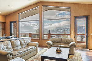 Living room featuring a mountain view, hardwood / wood-style flooring, and wooden walls