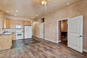 Kitchen featuring ceiling fan, white appliances, dark hardwood / wood-style flooring, light brown cabinetry, and sink