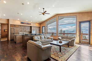 Living room with ceiling fan, dark hardwood / wood-style flooring, and a mountain view