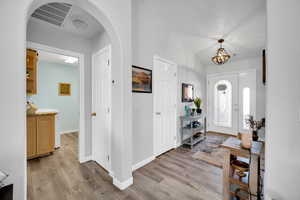 Entrance foyer featuring an inviting chandelier and light hardwood / wood-style floors