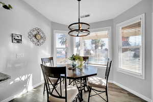 Dining space with an inviting chandelier and hardwood / wood-style floors