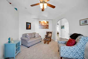 Living room with vaulted ceiling, ceiling fan, and carpet