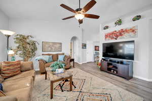 Living room with ceiling fan, vaulted ceiling, and light hardwood / wood-style flooring